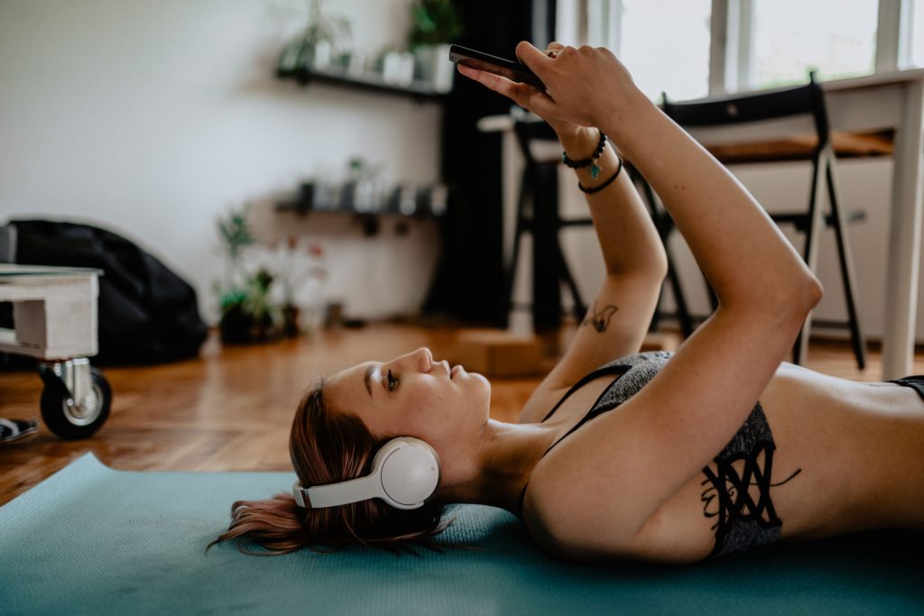Woman doing yoga listening to music through headphones